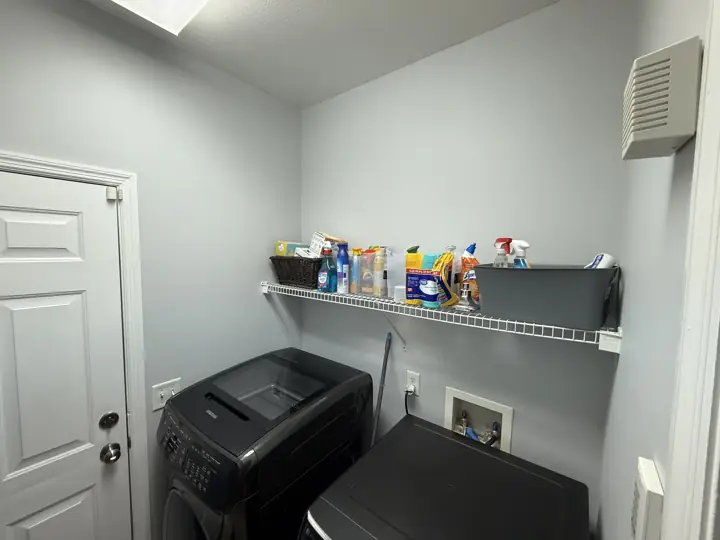 Laundry room with pale blue-gray walls and white door casing in Ooltewah, TN