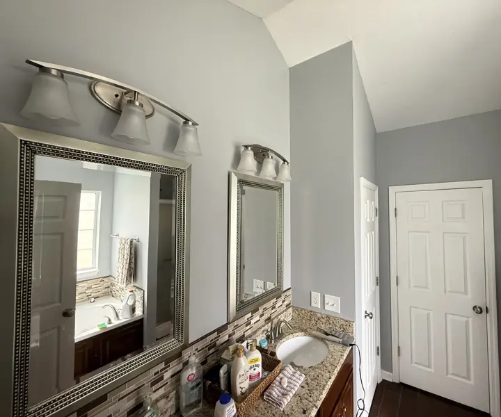 Primary bathroom with pale blue-gray walls, sloped ceiling and white six-panel doors in Ooltewah, TN