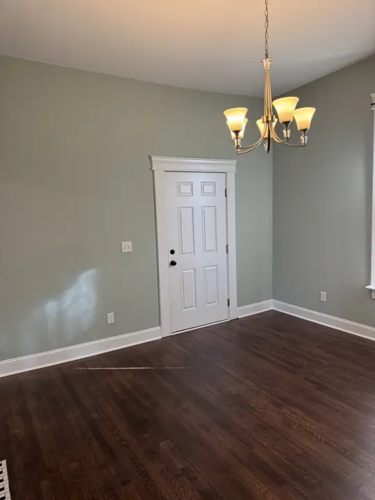 Sage green walls with white door casing and baseboards under a chandelier in Chattanooga, TN