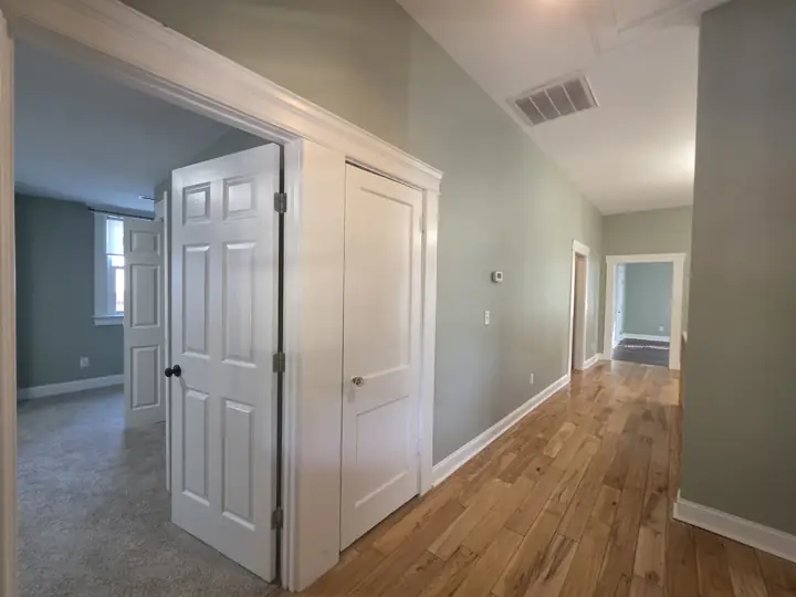 Sage green hallway with white six-panel doors and wide casings after painting in Chattanooga, TN