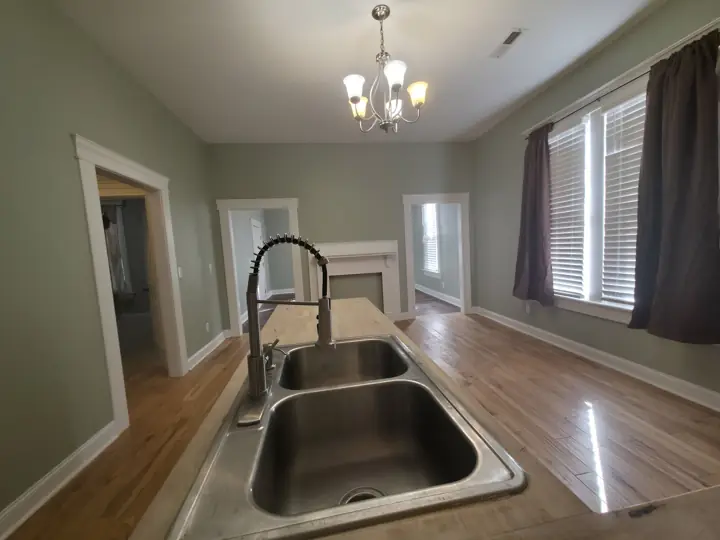 View from kitchen sink into sage green rooms with white door trim in Chattanooga, TN