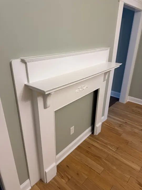Side view of white painted fireplace mantel shelf and brackets after interior painting in Chattanooga, TN
