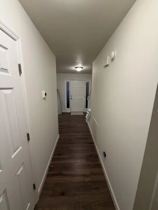 Hallway to the front door with warm white walls and white baseboards, Chattanooga, TN