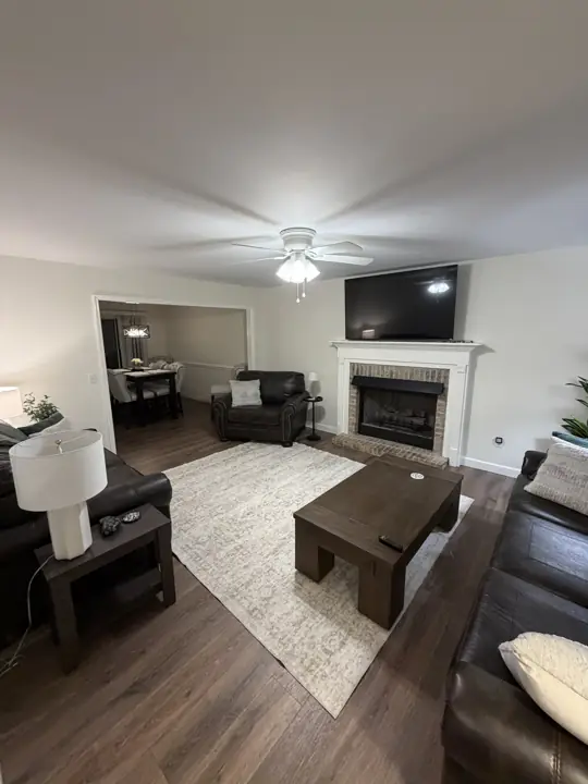 Living room with warm white walls and a white mantel on a brick fireplace, Chattanooga, TN