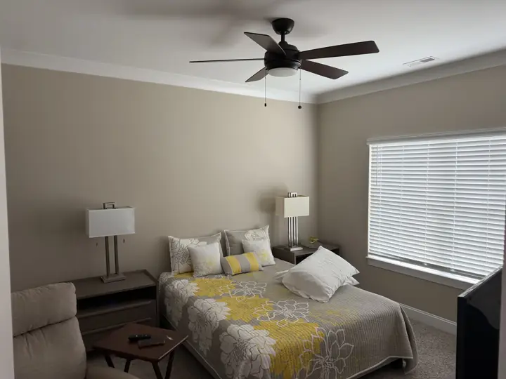 Bedroom with warm beige walls, white crown molding and window trim after painting in Chattanooga, TN