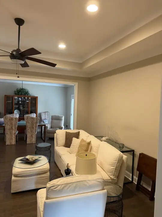 Living room with warm beige walls and a two-step white tray ceiling after painting in Chattanooga, TN