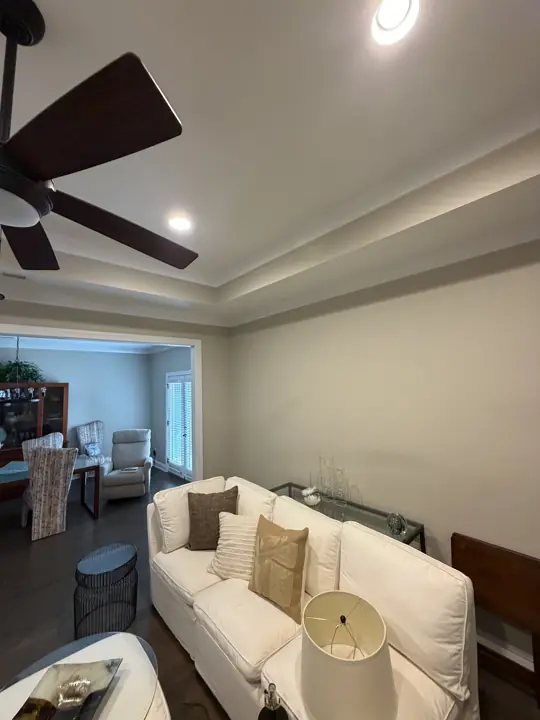 Wide view of tray ceiling steps and beige walls above a white sofa in Chattanooga, TN