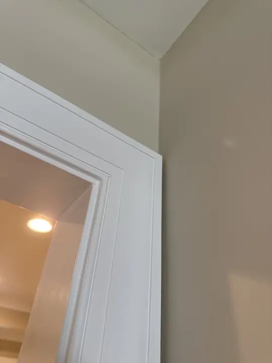 Corner of white painted fluted door trim meeting a warm beige wall in Chattanooga, TN