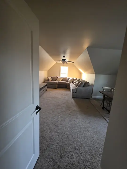 Bonus room with sloped ceilings and white door after interior painting in Cleveland, TN