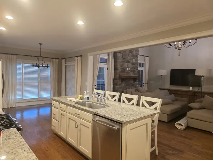 Open kitchen and living room with greige walls and white crown molding in Cleveland, TN