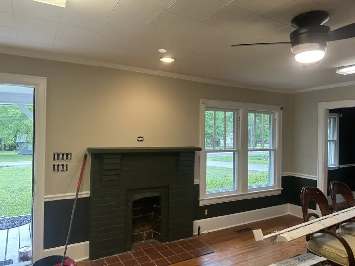 Painted charcoal brick fireplace between greige walls and white-trimmed windows in Ringgold, GA
