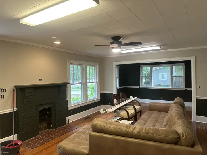 Living room with charcoal painted brick fireplace, greige walls and white crown molding in Ringgold, GA