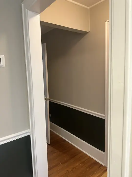Hallway with greige upper wall, near-black lower wall and white chair rail and baseboard in Ringgold, GA