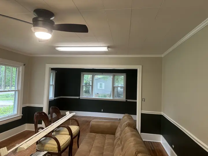 Two-tone living room with greige upper walls, near-black lower walls and white cased opening in Ringgold, GA