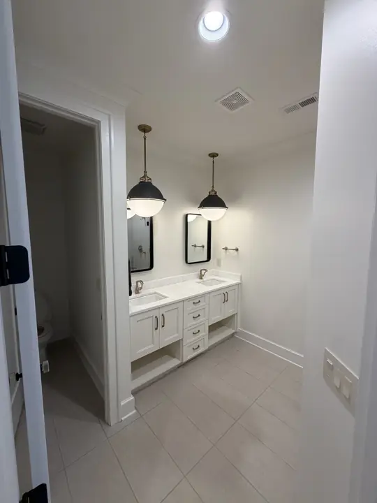 White bathroom walls with double vanity, white door casing and baseboards in Chattanooga, TN