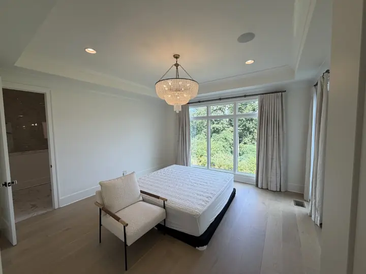 Warm white bedroom with layered tray ceiling, crown molding and tall windows in Chattanooga, TN