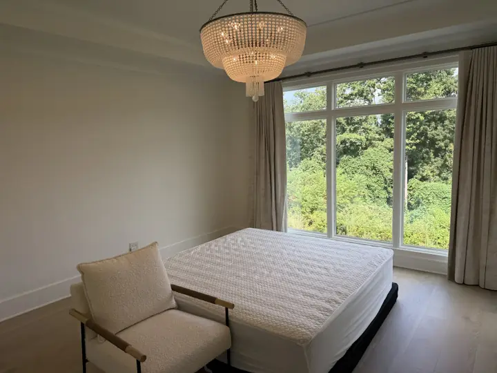 Warm white bedroom walls and baseboards beside a large window wall in Chattanooga, TN