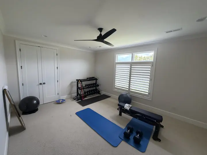 Home gym with warm white walls, white double closet doors and crown molding in Chattanooga, TN