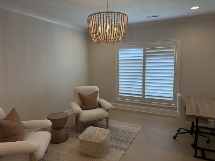 Warm white walls and crown molding around plantation shutters in a sitting room in Chattanooga, TN