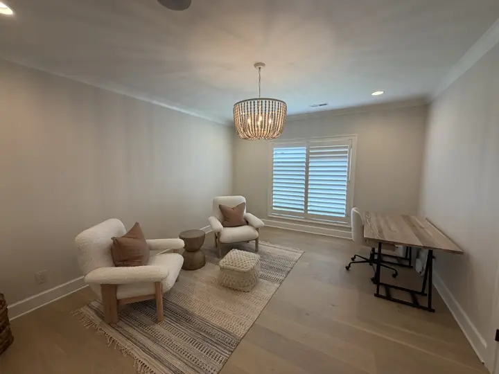 Sitting room with warm white walls, crown molding and white plantation shutters in Chattanooga, TN