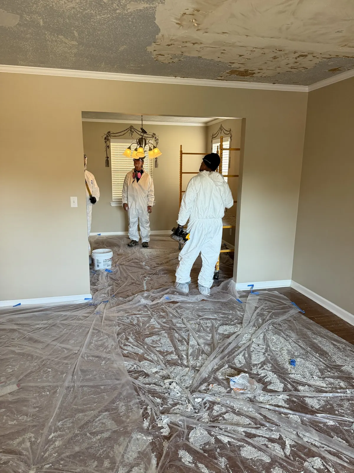 Floors covered in plastic sheeting while ceiling texture is scraped in Chattanooga, TN
