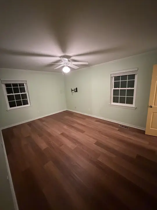 Bedroom with mint green walls, two windows and white baseboards in Chattanooga, TN