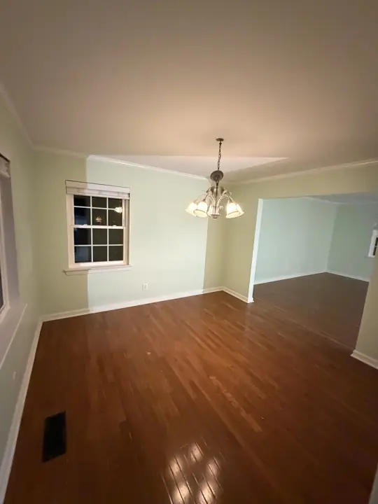 Mint green dining room opening to the living room with white baseboards in Chattanooga, TN
