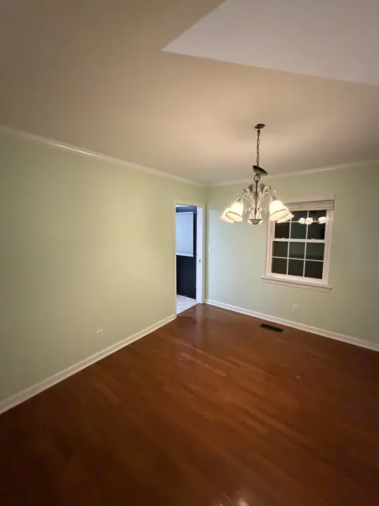 Dining room with soft green walls, white crown molding and hardwood floor in Chattanooga, TN
