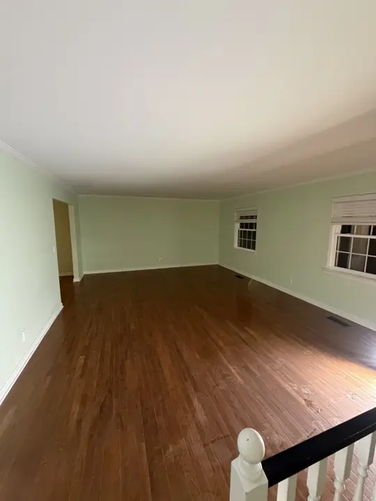 Long living room with pale mint green walls and white trim after interior painting in Chattanooga, TN