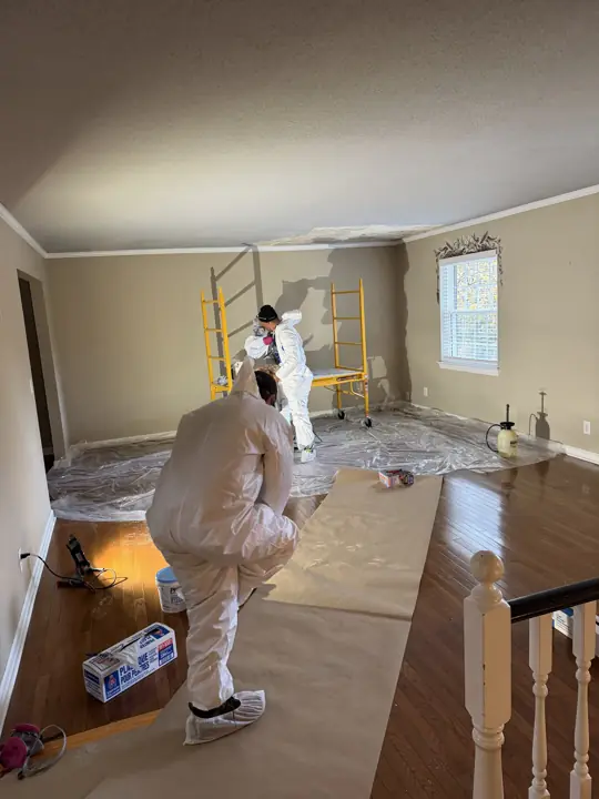 Crew on scaffold scraping a textured ceiling over protected floors in Chattanooga, TN