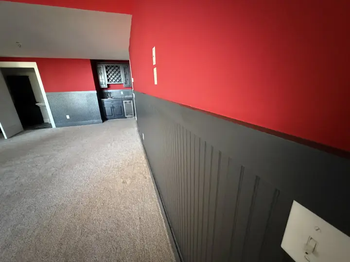 Close view of charcoal beadboard wainscoting meeting a red painted wall in Harrison, TN