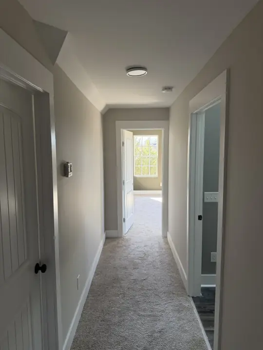 Upstairs hallway with light gray walls and white doors and casings in Harrison, TN