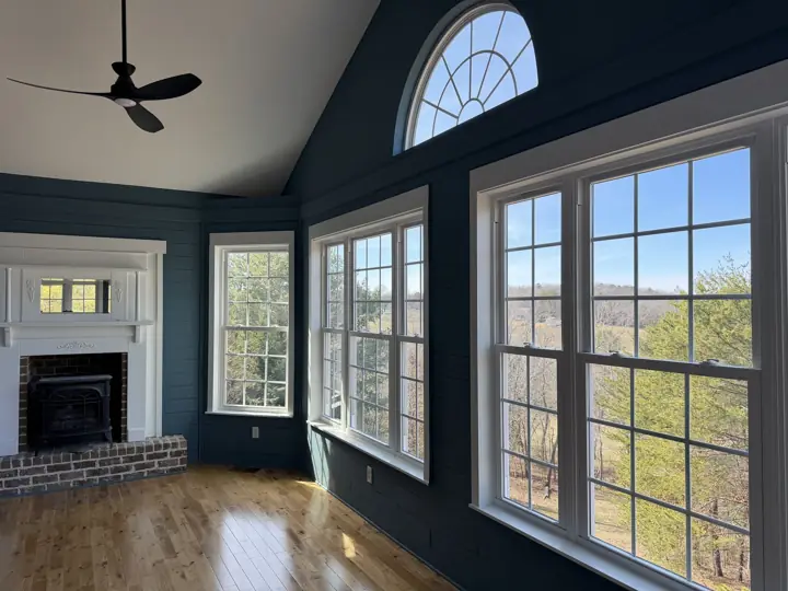 Sunroom with deep navy shiplap, white window trim and arched transom after interior painting in Harrison, TN