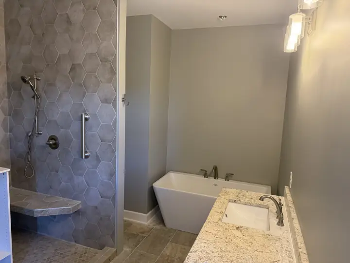 Primary bathroom with soft gray walls beside a freestanding tub and tiled shower in Harrison, TN
