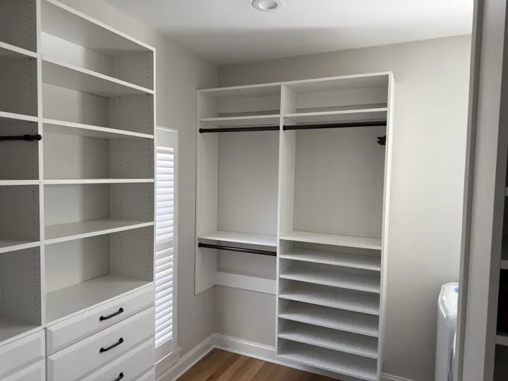 Walk-in closet with light gray walls and white built-in shelving in Harrison, TN
