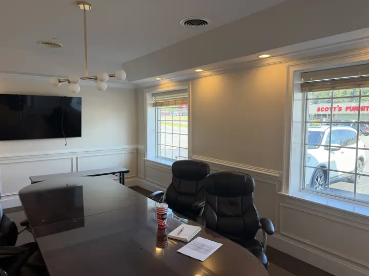 Conference room with white paneled wainscoting, window trim and crown molding in a Cleveland, TN office