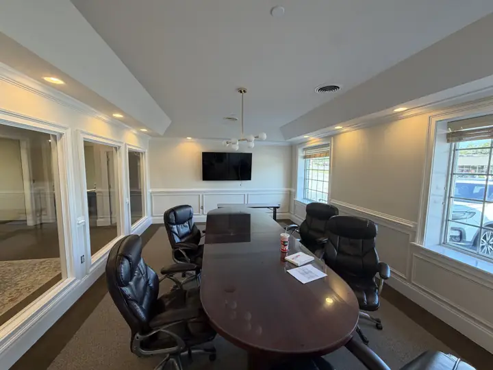 Office conference room with cream walls, white wainscoting and trimmed interior windows after painting in Cleveland, TN