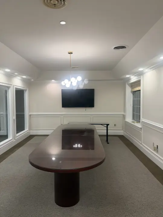 Conference room with tray ceiling, white paneled wainscoting and crown molding in a Cleveland, TN office