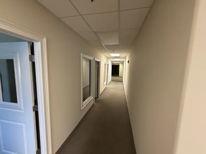 Office hallway with cream walls and white-framed interior windows after painting in Cleveland, TN