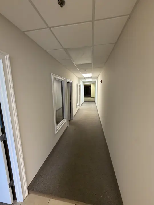 Narrow carpeted office hallway with white trim after commercial interior painting in Cleveland, TN