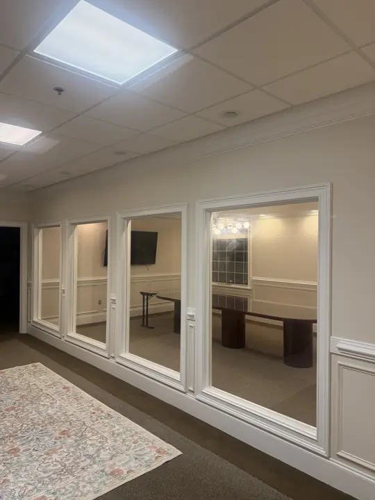 Row of interior office windows framed in white trim above wainscoting after painting in Cleveland, TN