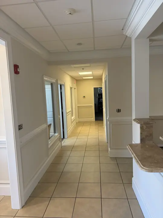 Tiled office hallway with cream walls, white chair rail panels and crown molding in Cleveland, TN