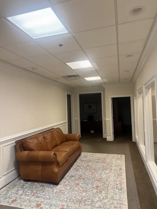 Office lounge with leather sofa, cream walls and white wainscoting after interior painting in Cleveland, TN