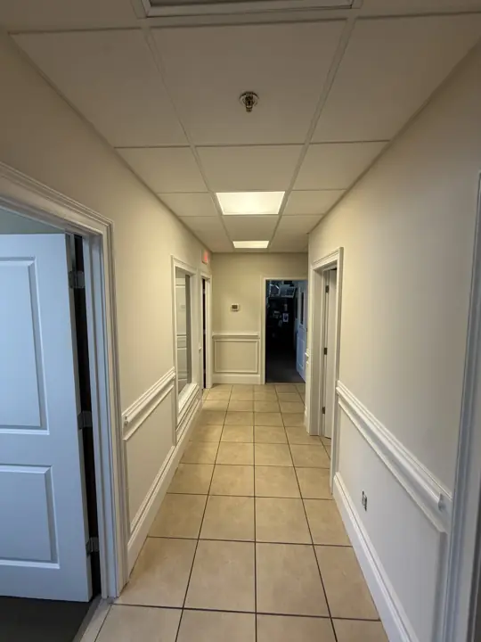 Tiled corridor with cream walls and white chair rail in a commercial office in Cleveland, TN