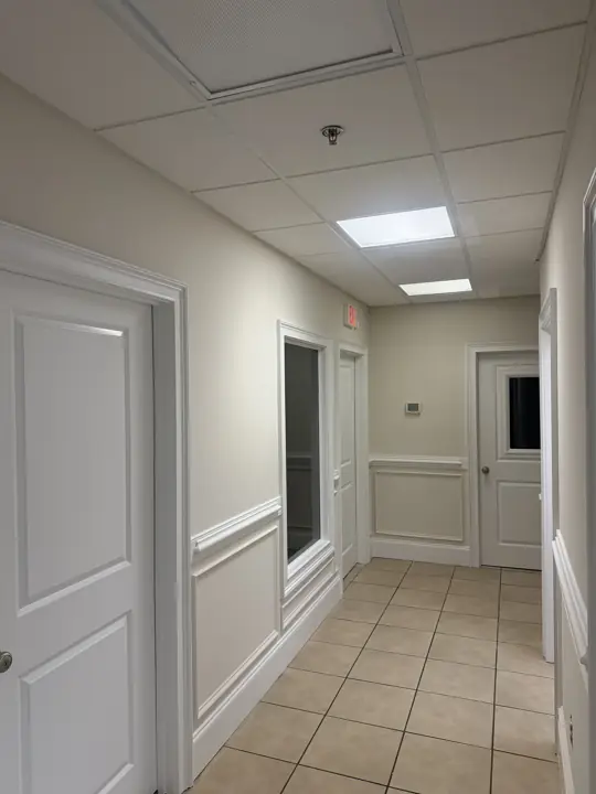 Office hallway with white doors, chair rail and paneled wainscoting after painting in Cleveland, TN