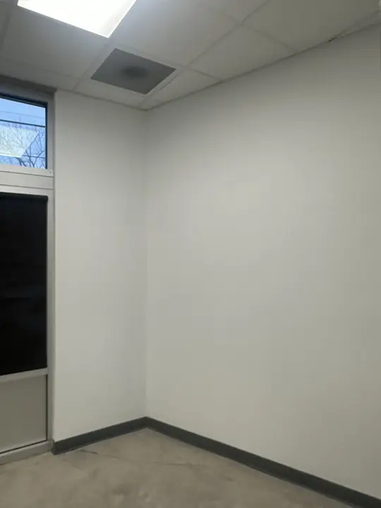 Corner of a white-painted office with dark baseboard and transom window in North Chattanooga, TN