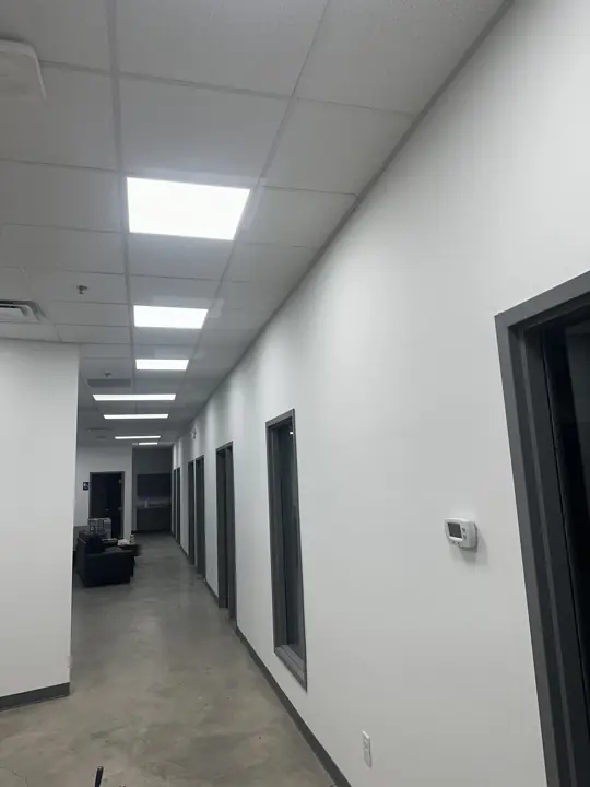 Long white office corridor with interior windows and gray trim after commercial painting in North Chattanooga, TN