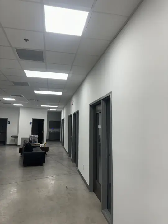 Bright white office hallway with gray door frames and drop ceiling after painting in North Chattanooga, TN