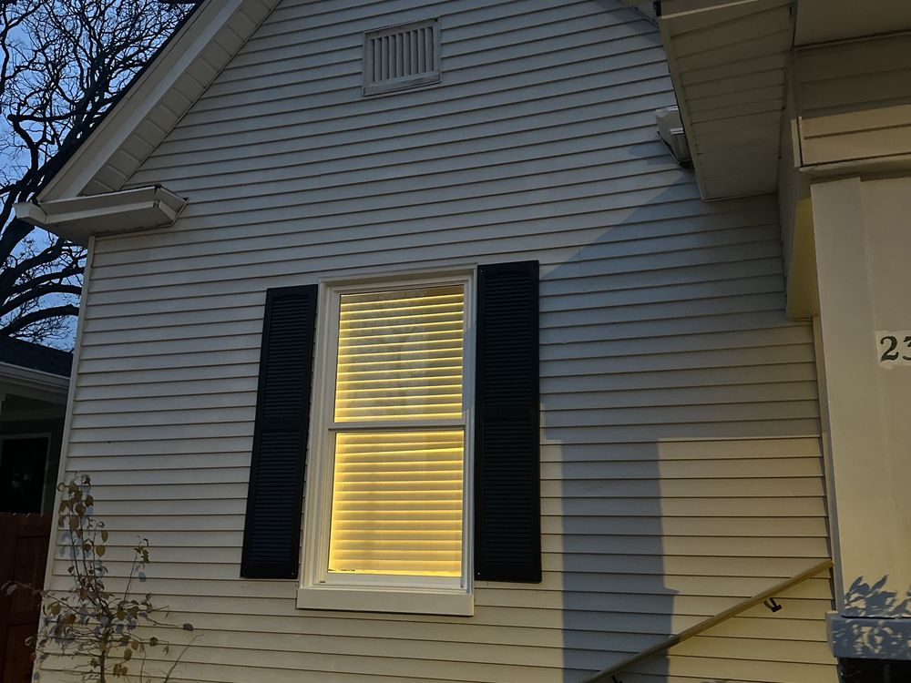 Freshly painted home exterior — white lap siding with black shutters