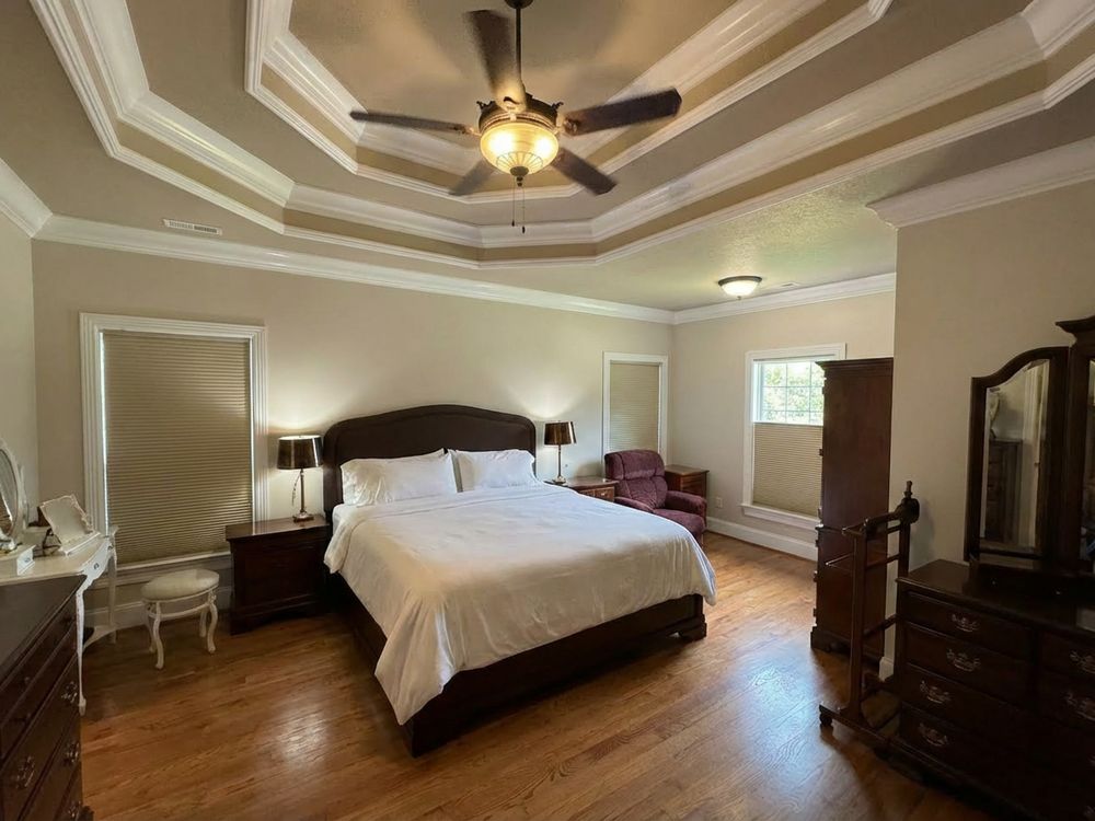 Furnished master bedroom with a tray ceiling